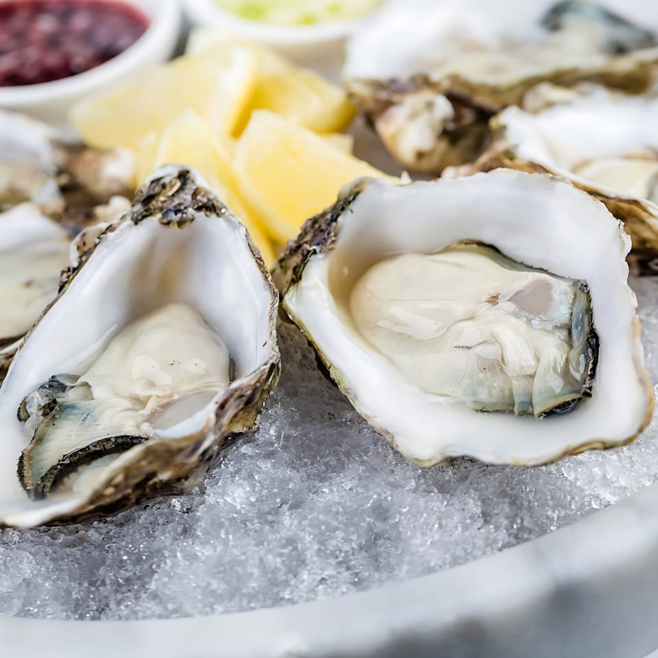 Fresh oysters on a bed of ice with lemon wedges and dipping sauces at Mickey's Downtown Bistro.