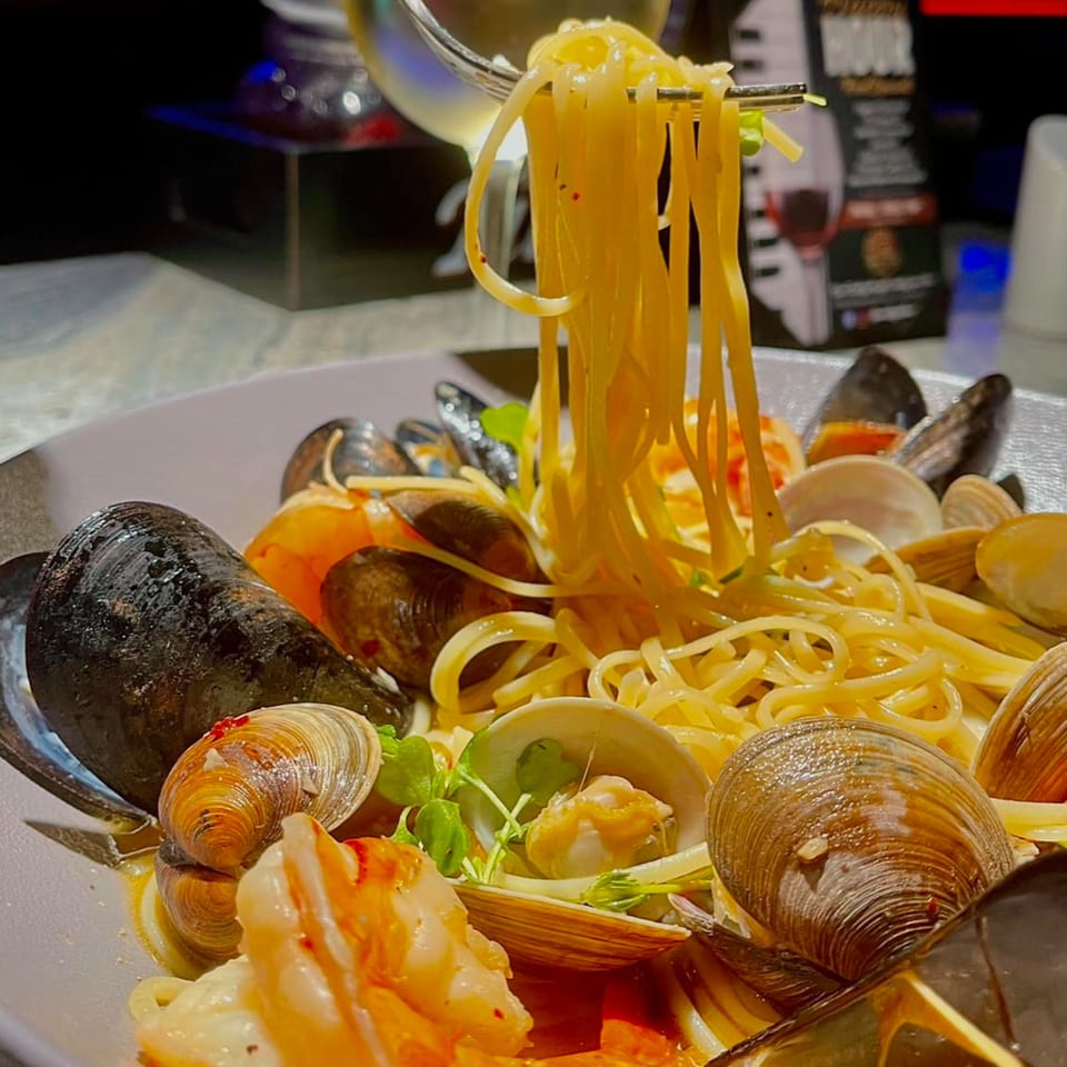A fork lifts spaghetti from a bowl of Mickey's Downtown Bistro's seafood pasta with mussels, clams, and shrimp.